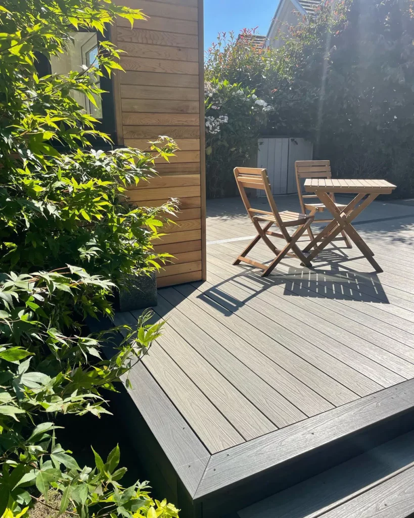 A comfortable outdoor living scene created with WPC decking, featuring a furnished patio with a table, chairs, and plants.