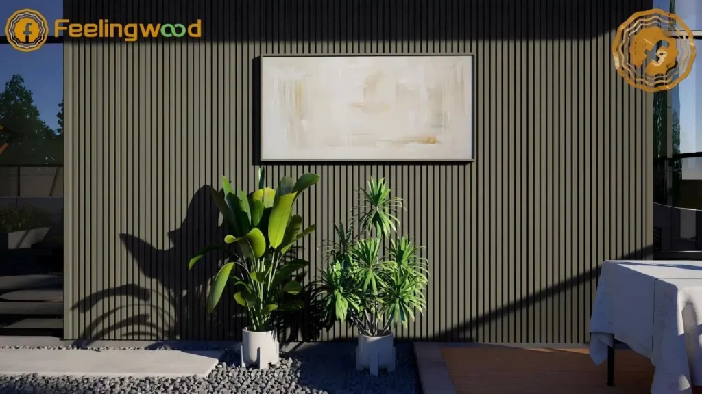 Contemporary outdoor patio wall clad in dark gray Feelingwood fluted wall panels, featuring a minimalist artwork, potted green plants, and sunlit shadows for a modern, serene outdoor living aesthetic.
