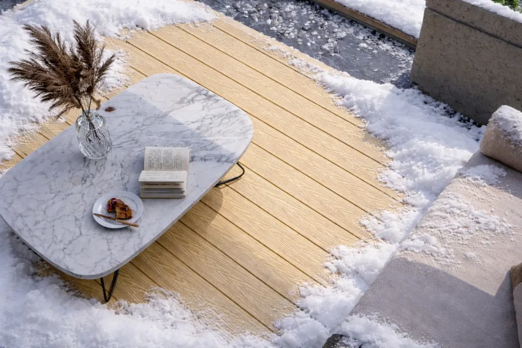 Light-colored Feelingwood WPC decking on a snow-covered Canadian residential patio—showcasing cold-climate durability for outdoor leisure spaces.