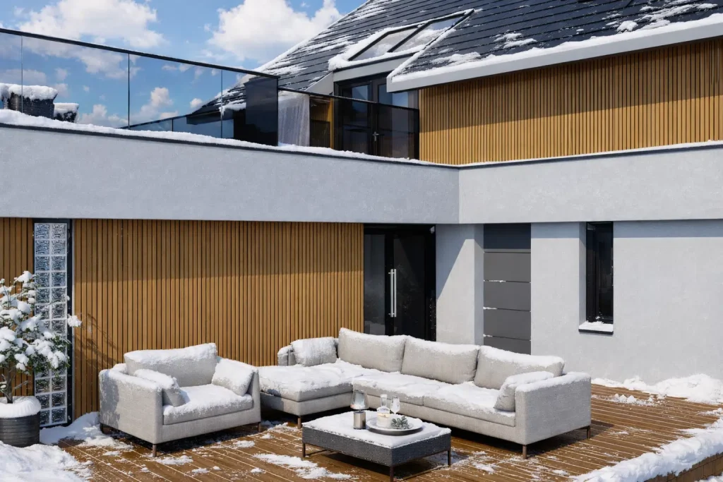 Modern Canadian backyard patio with durable WPC decking and vertical WPC cladding, snow-covered outdoor furniture, glass railing, and contemporary architecture, demonstrating WPC’s weather resistance in harsh winter conditions.